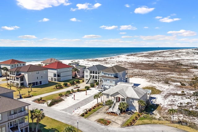 aerial view with a residential view, a view of the beach, and a water view