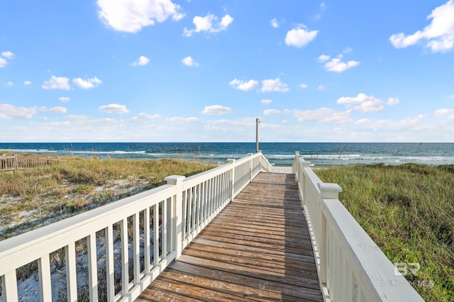 view of property's community with a water view and a beach view