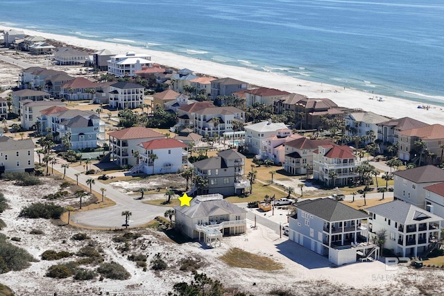 drone / aerial view with a residential view, a beach view, and a water view