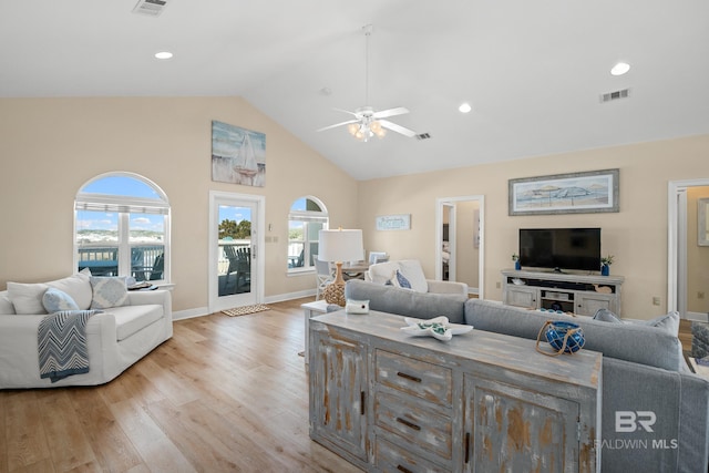 living area with a wealth of natural light, light wood-type flooring, baseboards, and visible vents