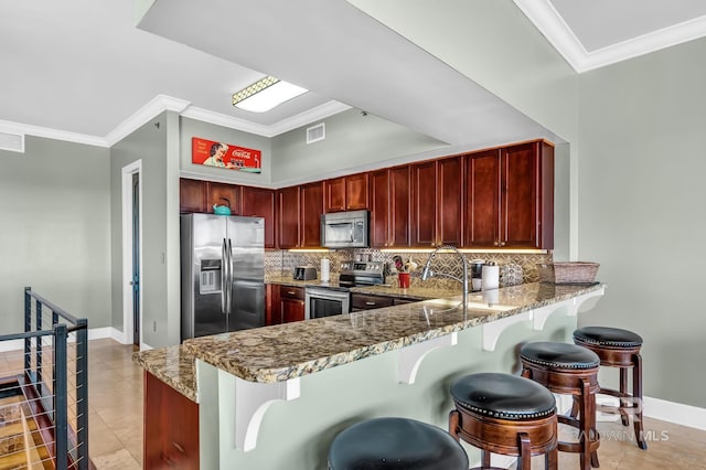 kitchen with reddish brown cabinets, light stone countertops, stainless steel appliances, and decorative backsplash