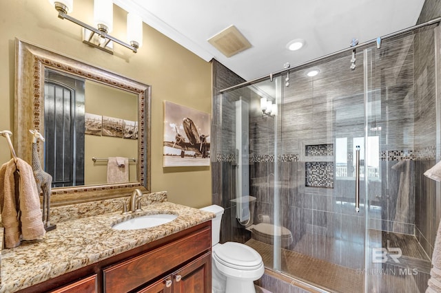 bathroom with a stall shower, visible vents, vanity, and toilet