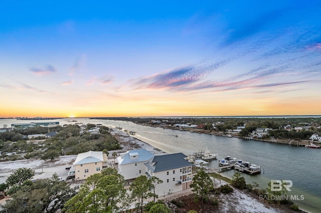 aerial view at dusk featuring a water view