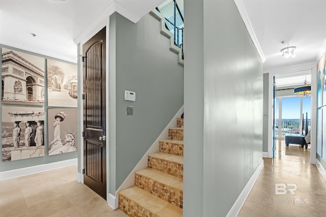 stairs featuring baseboards, ornamental molding, and tile patterned floors