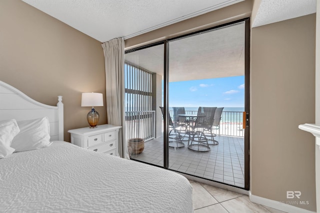 24720 Perdido Beach Blvd Unit 504, Orange Beach, AL 36561 - bedroom with access to outside, light tile patterned floors, a textured ceiling, baseboards, and a water view