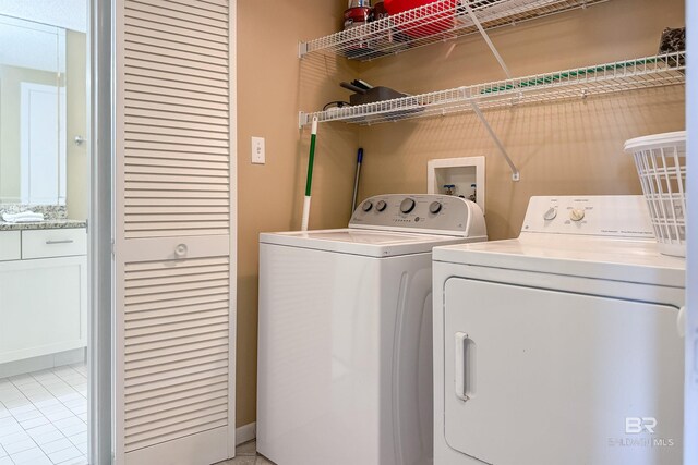 24720 Perdido Beach Blvd Unit 504, Orange Beach, AL 36561 - laundry room with separate washer and dryer and light tile patterned floors