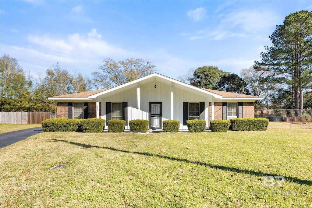 ranch-style home with a front yard and a porch