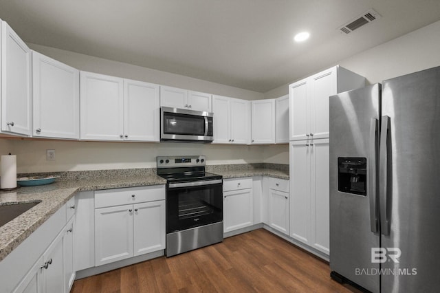 169 Buena Vista Dr, Daphne, AL 36526 - kitchen with appliances with stainless steel finishes, white cabinetry, dark wood-type flooring, recessed lighting, and light stone countertops
