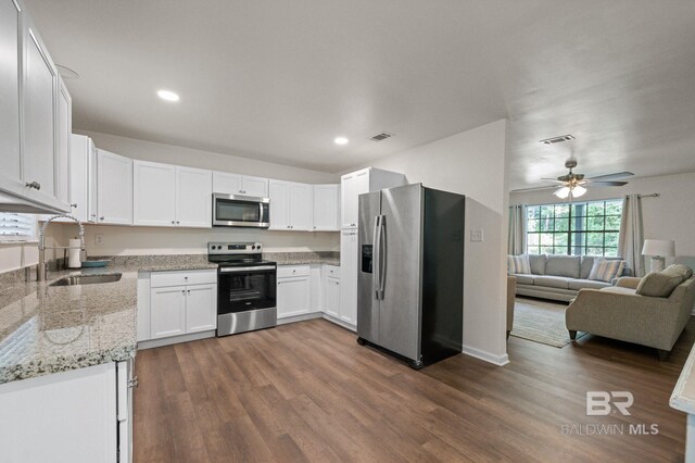 169 Buena Vista Dr, Daphne, AL 36526 - kitchen with stainless steel appliances, a sink, light stone countertops, a ceiling fan, and white cabinetry