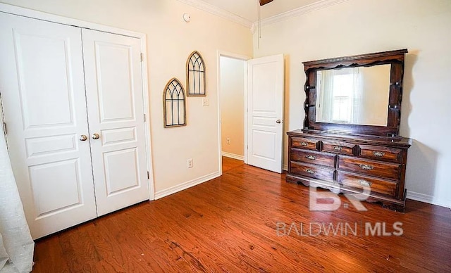 bedroom with crown molding, dark hardwood / wood-style floors, and a closet