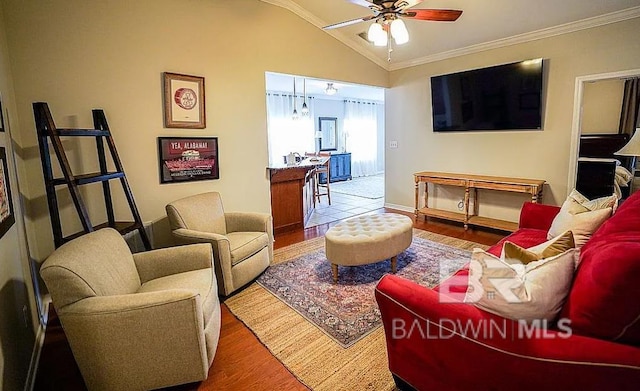 living room with lofted ceiling, wood-type flooring, crown molding, and ceiling fan