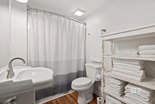 bathroom with sink, a shower with shower curtain, wood-type flooring, and toilet