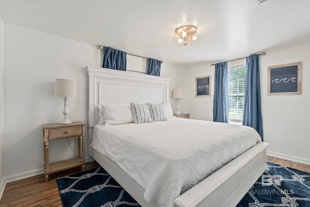 bedroom with dark hardwood / wood-style floors