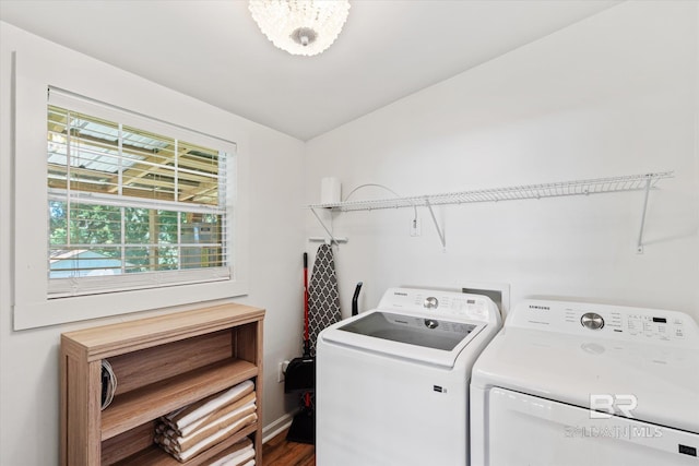 clothes washing area featuring hardwood / wood-style floors and washing machine and clothes dryer