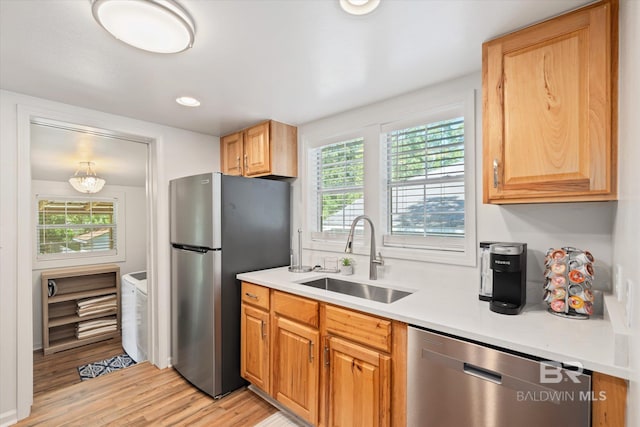 kitchen featuring stainless steel appliances, light hardwood / wood-style flooring, and sink