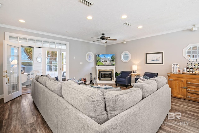 living room with a textured ceiling, crown molding, ceiling fan, and dark hardwood / wood-style floors