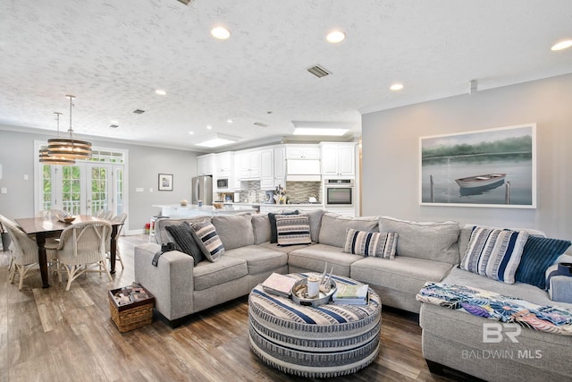 living room with ornamental molding, a textured ceiling, and hardwood / wood-style flooring