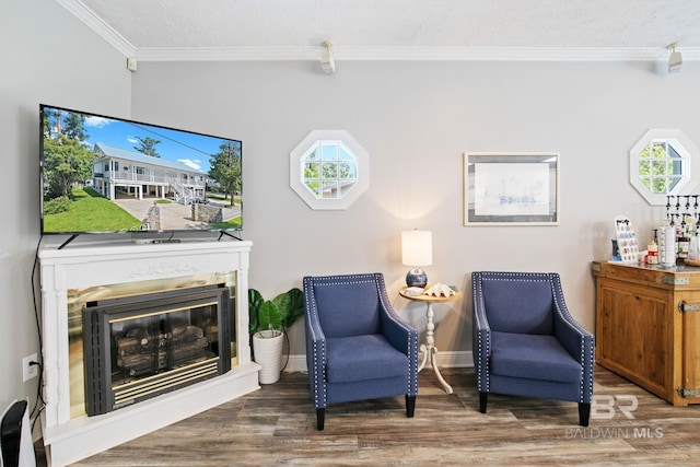 living area with hardwood / wood-style flooring, a wealth of natural light, and ornamental molding