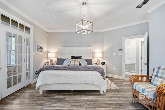 bedroom with a chandelier, crown molding, and dark wood-type flooring