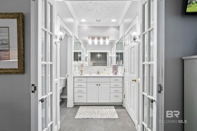 bathroom featuring french doors, tile patterned floors, vanity, crown molding, and toilet