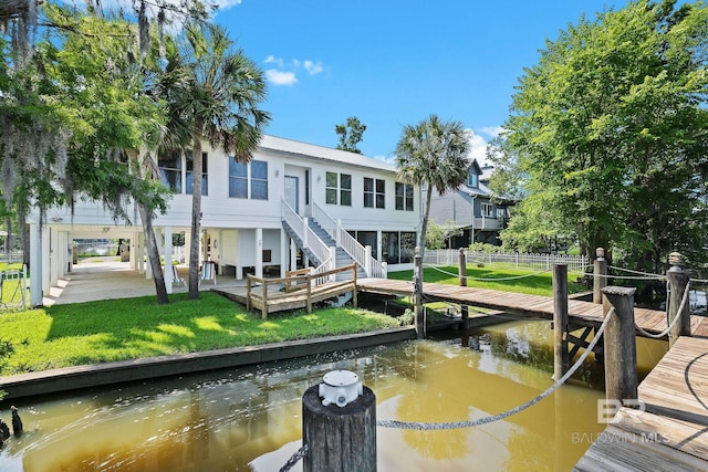 view of dock featuring a lawn and a water view