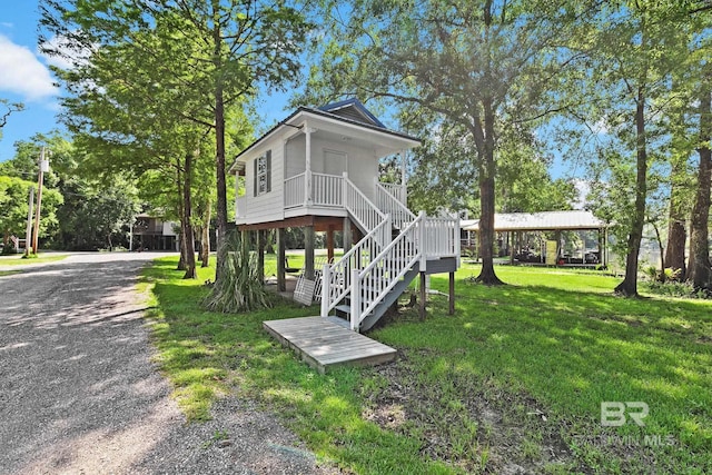 exterior space featuring covered porch and a yard