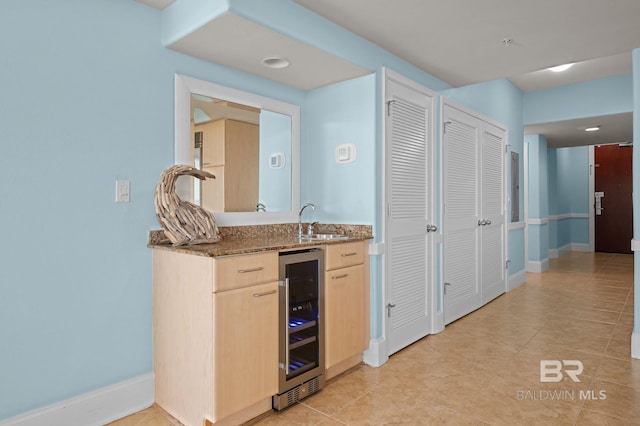 28103 Perdido Beach Blvd Unit B 516, Orange Beach, AL 36561 - kitchen with wine cooler, a sink, dark stone countertops, baseboards, and light tile patterned floors