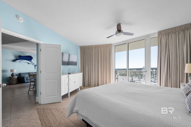 28103 Perdido Beach Blvd Unit B 516, Orange Beach, AL 36561 - tiled bedroom featuring access to exterior, a textured ceiling, lofted ceiling, a ceiling fan, and expansive windows