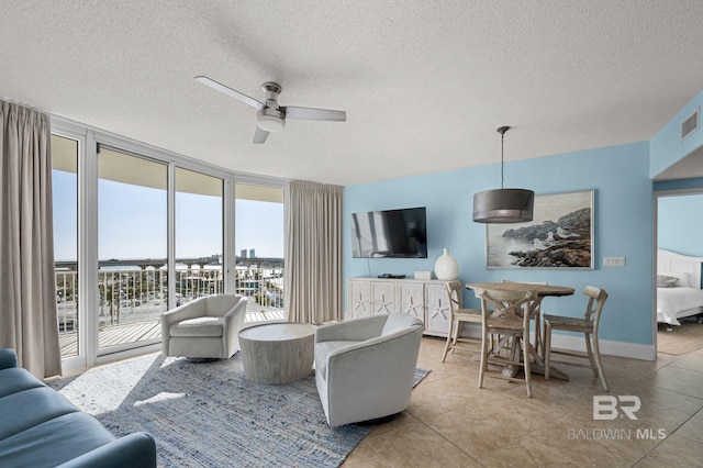 28103 Perdido Beach Blvd Unit B 516, Orange Beach, AL 36561 - living room featuring floor to ceiling windows, a ceiling fan, a textured ceiling, tile patterned floors, and baseboards