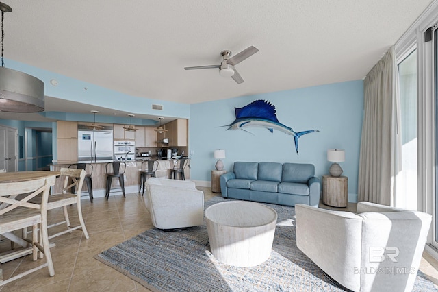 28103 Perdido Beach Blvd Unit B 516, Orange Beach, AL 36561 - living room featuring a ceiling fan, light tile patterned floors, healthy amount of natural light, and a textured ceiling