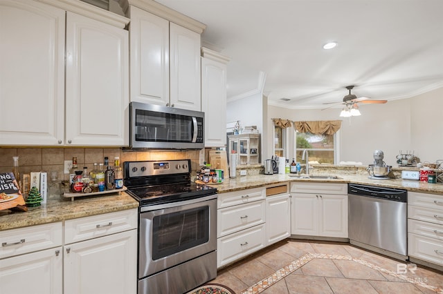 3340 Deer Track Dr, Semmes, AL 36575 - kitchen featuring appliances with stainless steel finishes, ornamental molding, decorative backsplash, a ceiling fan, and light tile patterned flooring