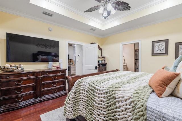 3340 Deer Track Dr, Semmes, AL 36575 - bedroom featuring a raised ceiling, dark wood-type flooring, ornamental molding, and connected bathroom
