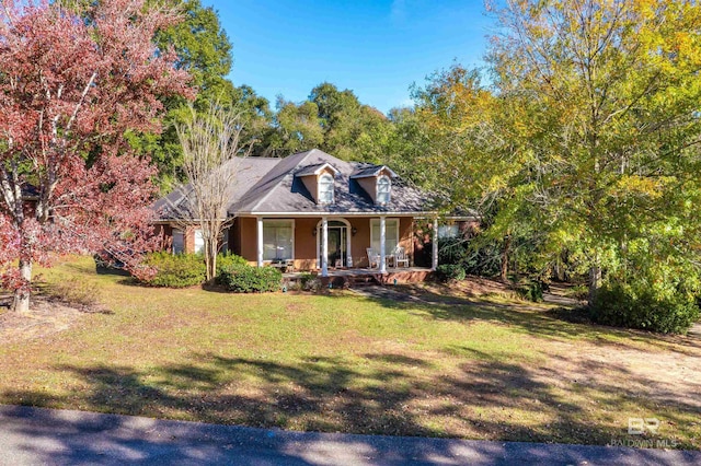 cape cod home featuring covered porch and a front yard