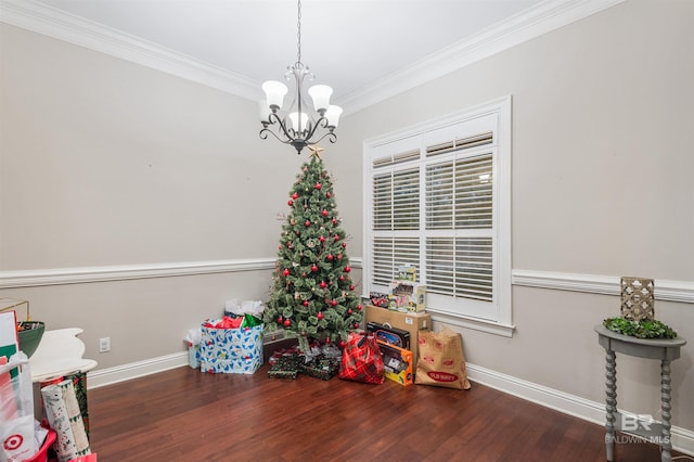 rec room with crown molding, dark hardwood / wood-style floors, and a notable chandelier