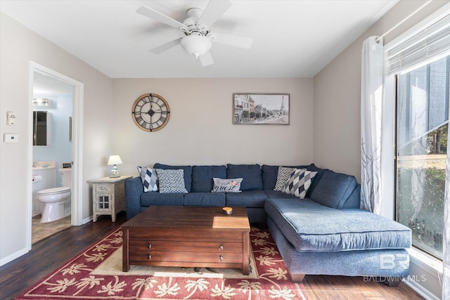 living room with dark wood-type flooring and ceiling fan