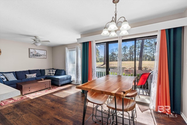 dining area with ceiling fan with notable chandelier and hardwood / wood-style floors