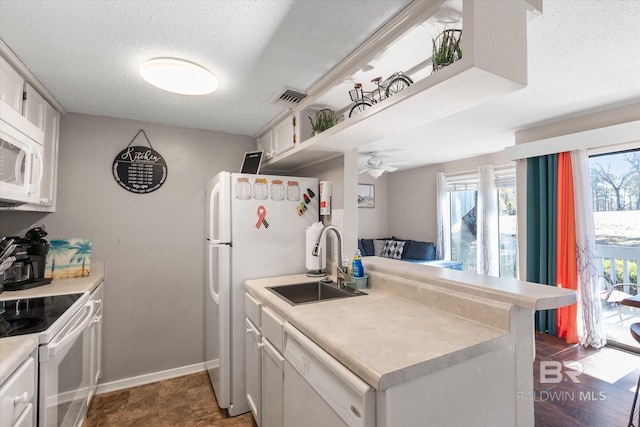 kitchen featuring white appliances, sink, a textured ceiling, and white cabinets