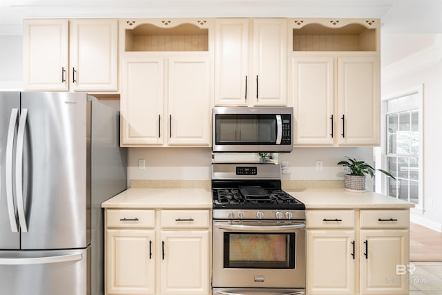 kitchen featuring appliances with stainless steel finishes, light tile patterned floors, and cream cabinetry