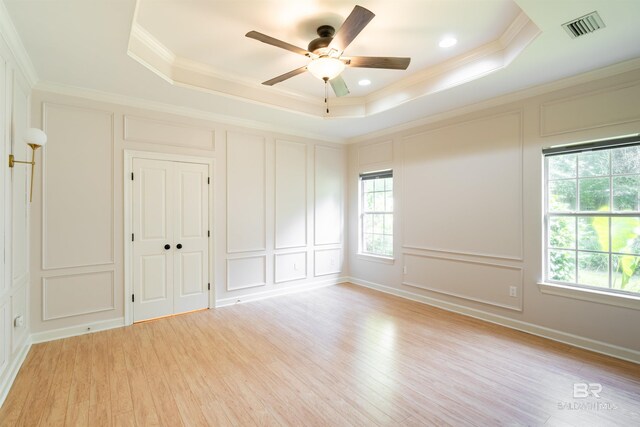 unfurnished bedroom with multiple windows and a raised ceiling