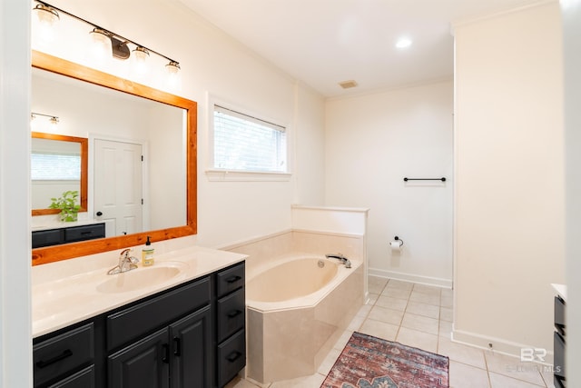 bathroom with a bathing tub, vanity, and tile patterned floors