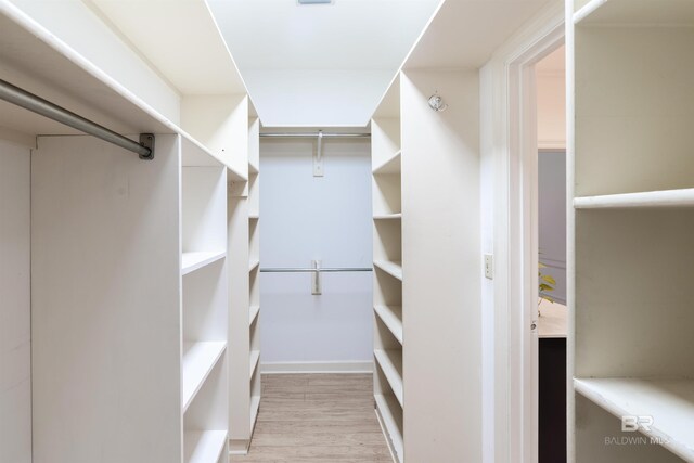 spacious closet with light hardwood / wood-style floors