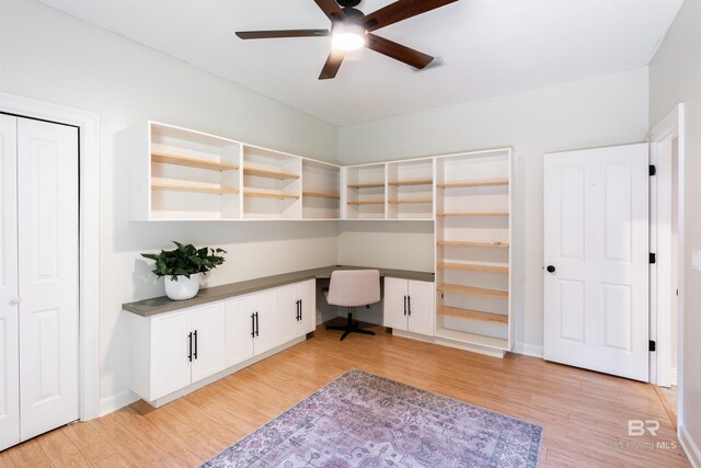 office featuring built in desk, ceiling fan, and light hardwood / wood-style flooring