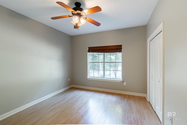 unfurnished bedroom with light hardwood / wood-style flooring, ceiling fan, and a closet