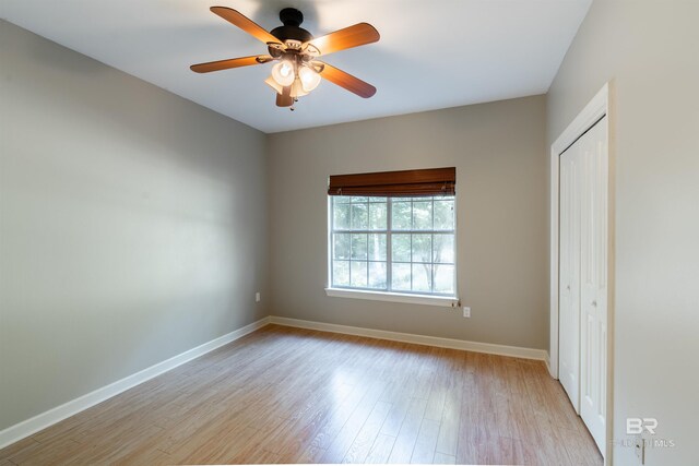 unfurnished bedroom featuring ceiling fan, light hardwood / wood-style floors, and a closet