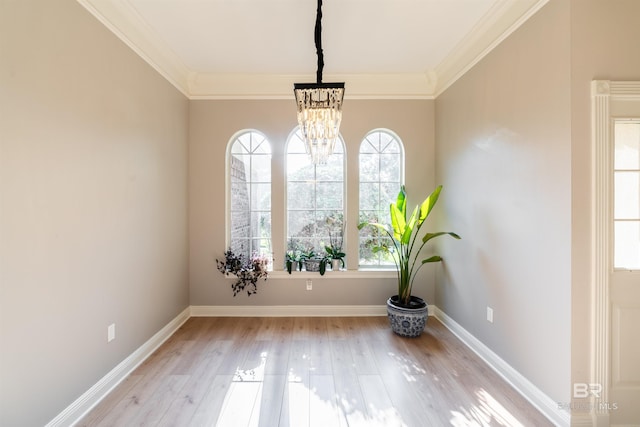 unfurnished room featuring crown molding, a chandelier, and light wood-type flooring