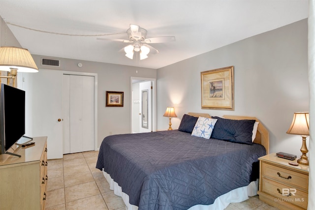 tiled bedroom with ceiling fan and a closet