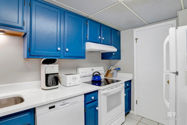 kitchen with blue cabinets, light tile patterned floors, and white appliances