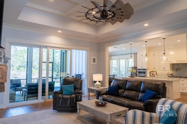 living area with light wood finished floors, coffered ceiling, beam ceiling, and recessed lighting