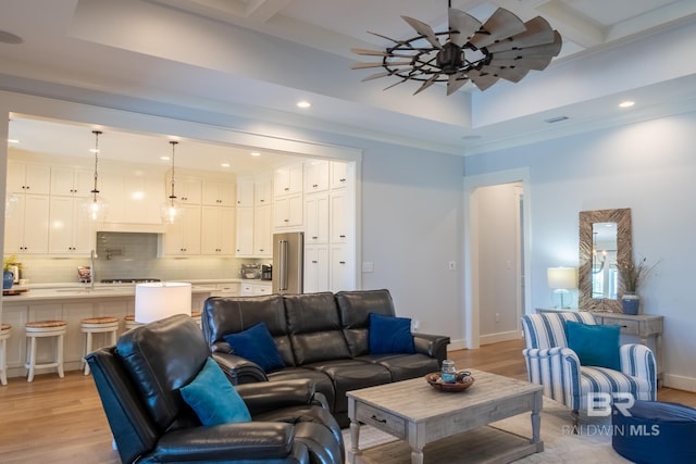 living area featuring light wood finished floors, beam ceiling, and baseboards