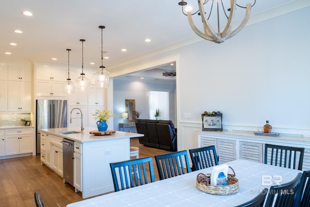 dining area with a wainscoted wall, crown molding, recessed lighting, a decorative wall, and wood finished floors